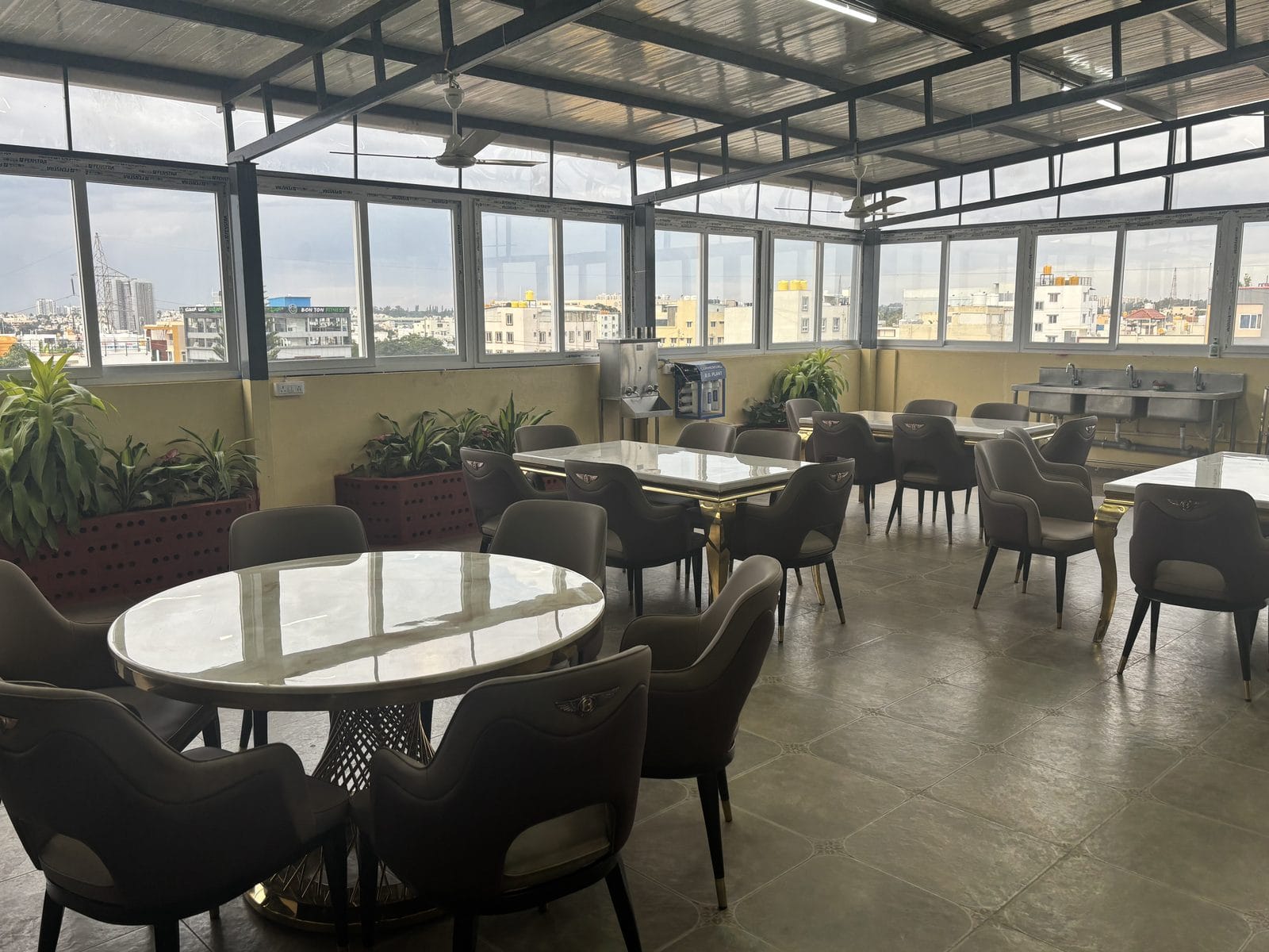 The rooftop dining hall at Infinity Space PG, Yeshwanthpur — glass-walled with a view across the city